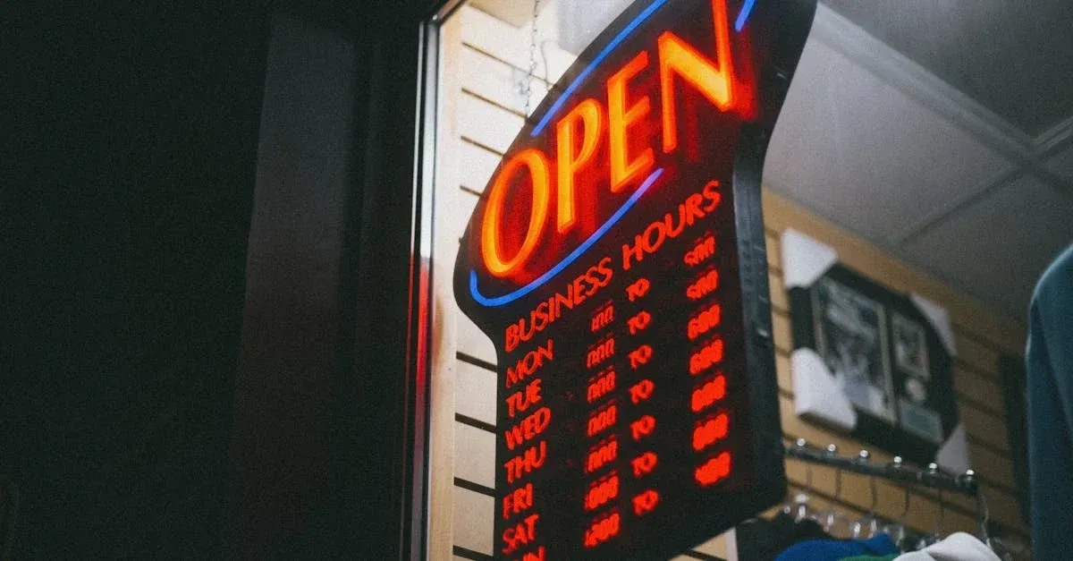 Neon open sign with business hours displayed on storefront window at night.