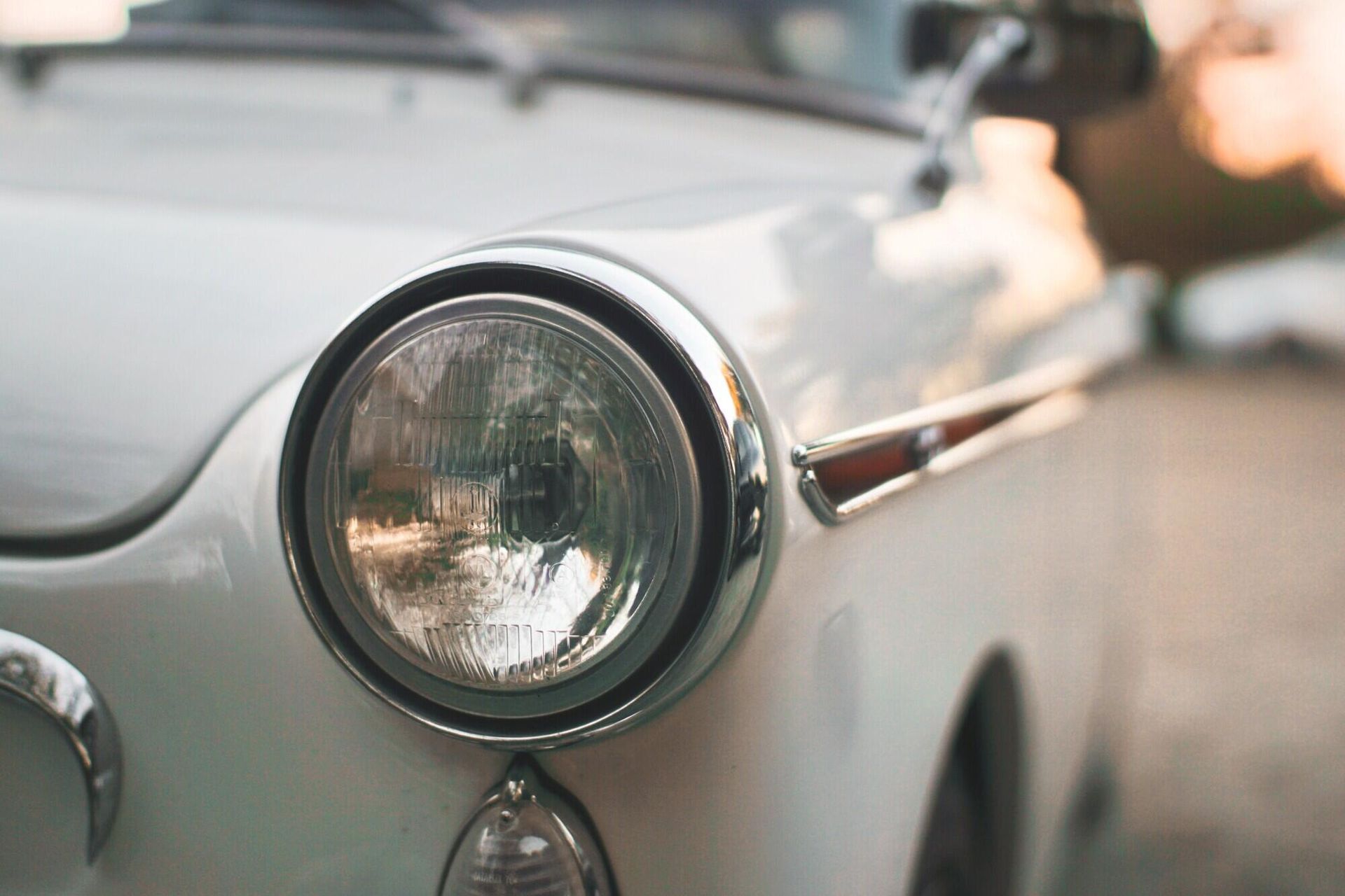 White vintage car headlight and body detail.
