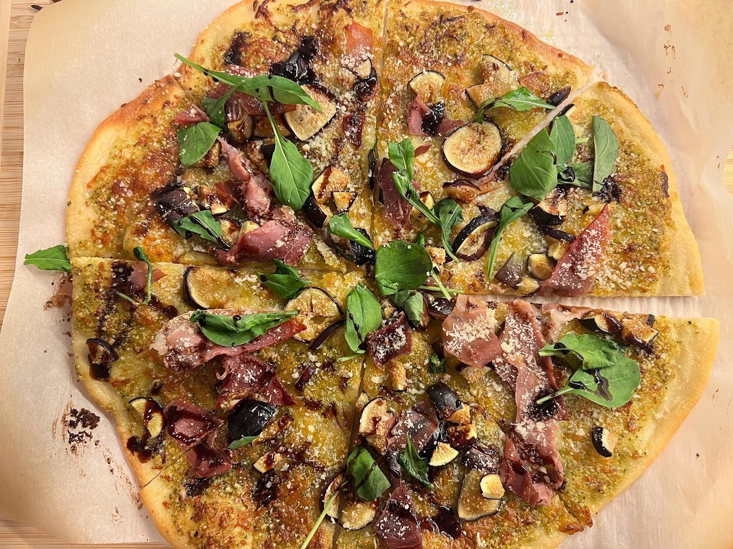 A pizza with a lot of toppings on it is sitting on a table.