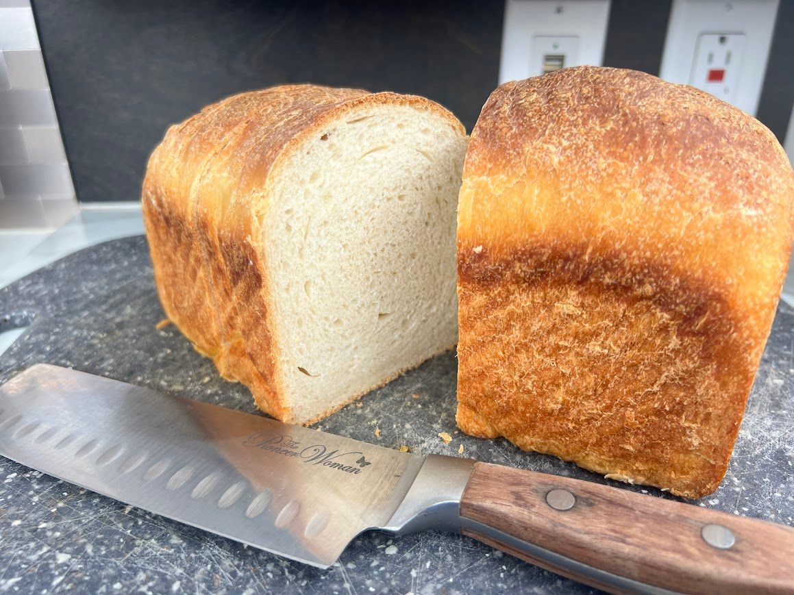a loaf of bread cut in half is sitting on a cutting board