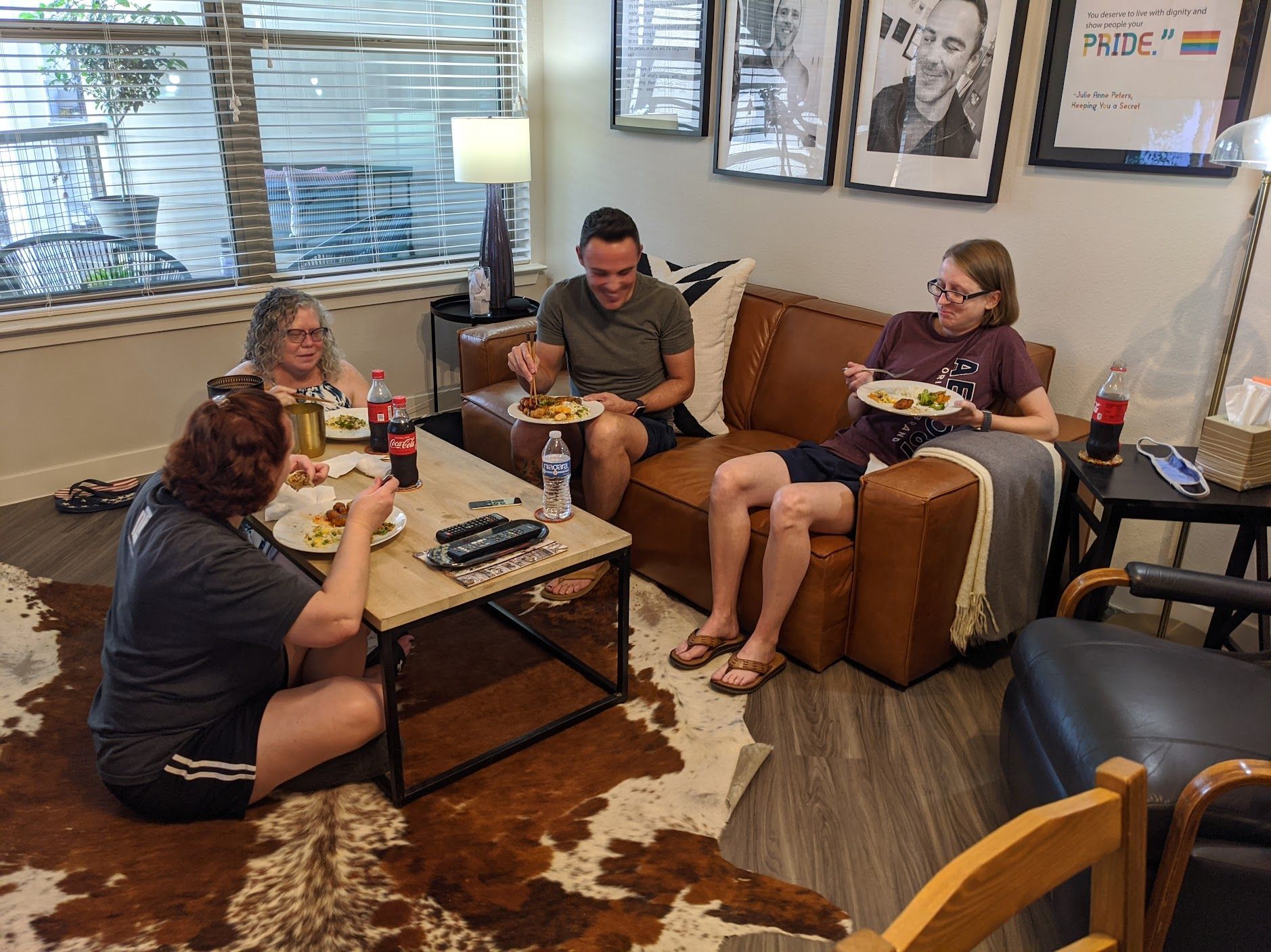 A group of people are sitting on a couch eating food.