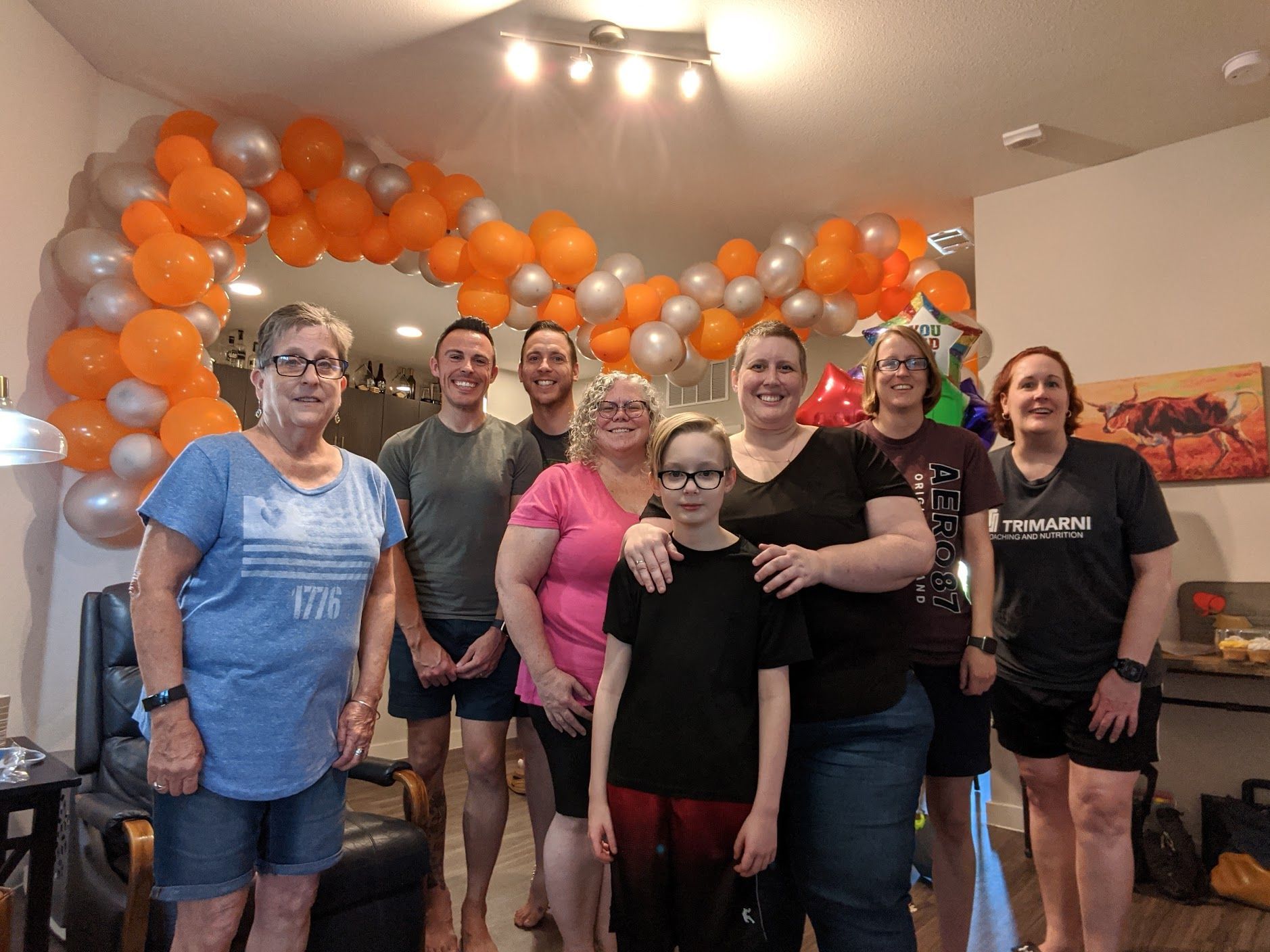 A group of people are posing for a picture in front of balloons.