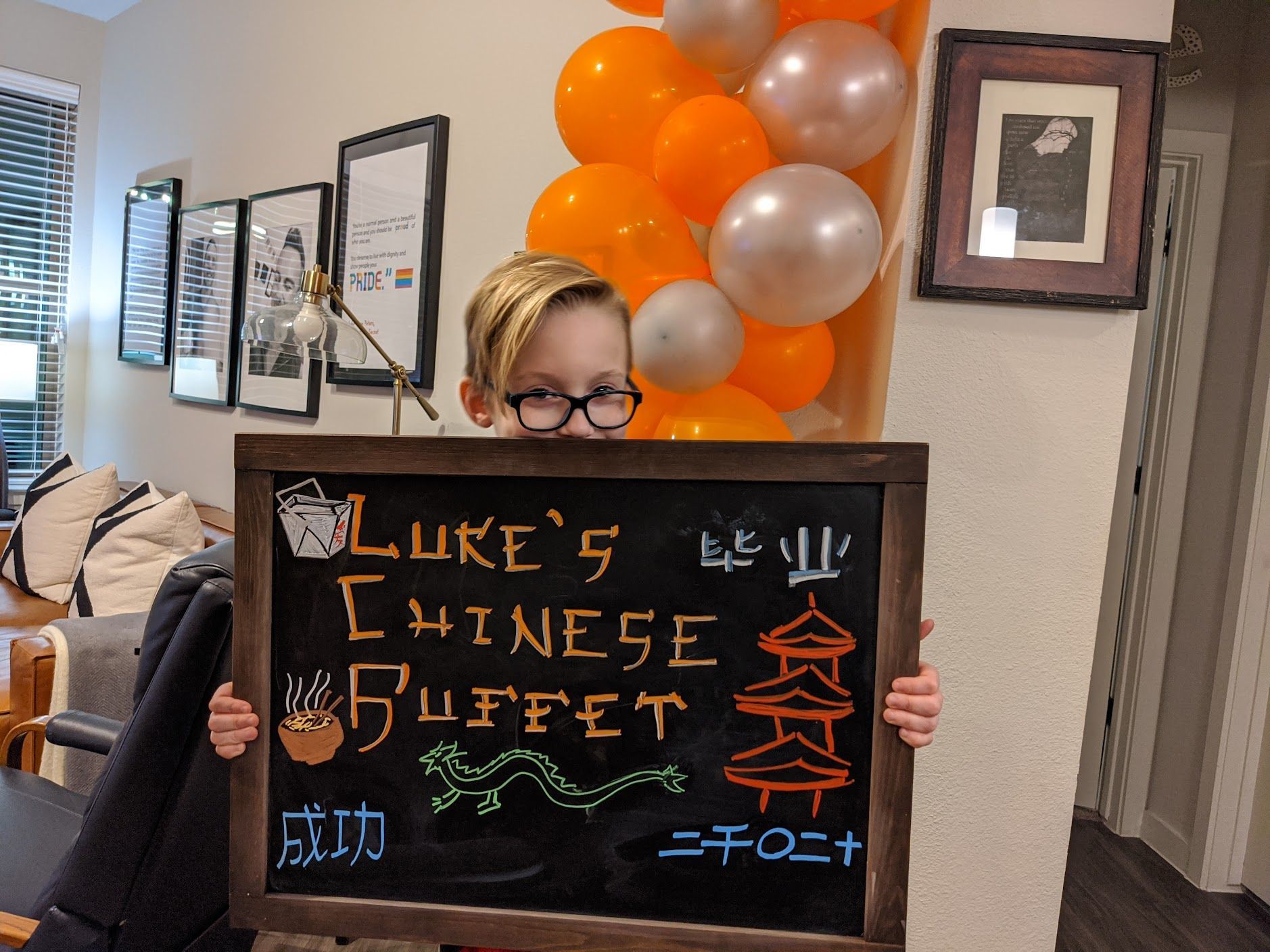 A young boy is holding a sign that says luke 's chinese buffet