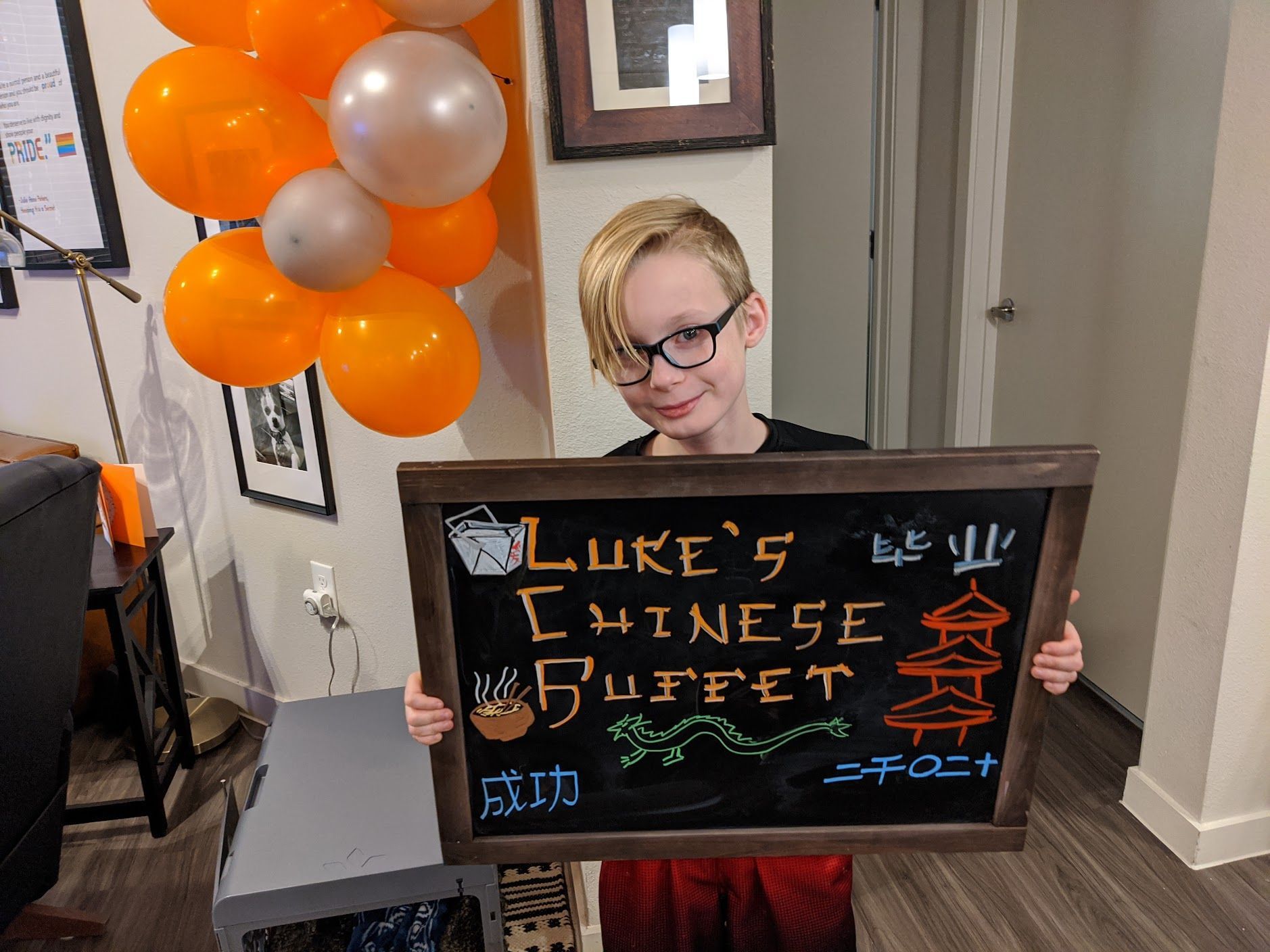 A young boy is holding a sign that says luke's chinese buffet.