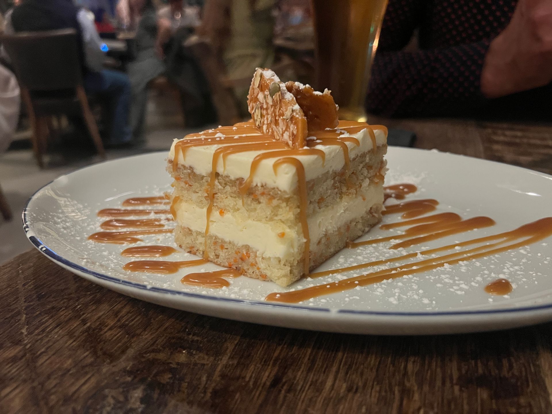 a piece of carrot cake on a plate in a restaurant