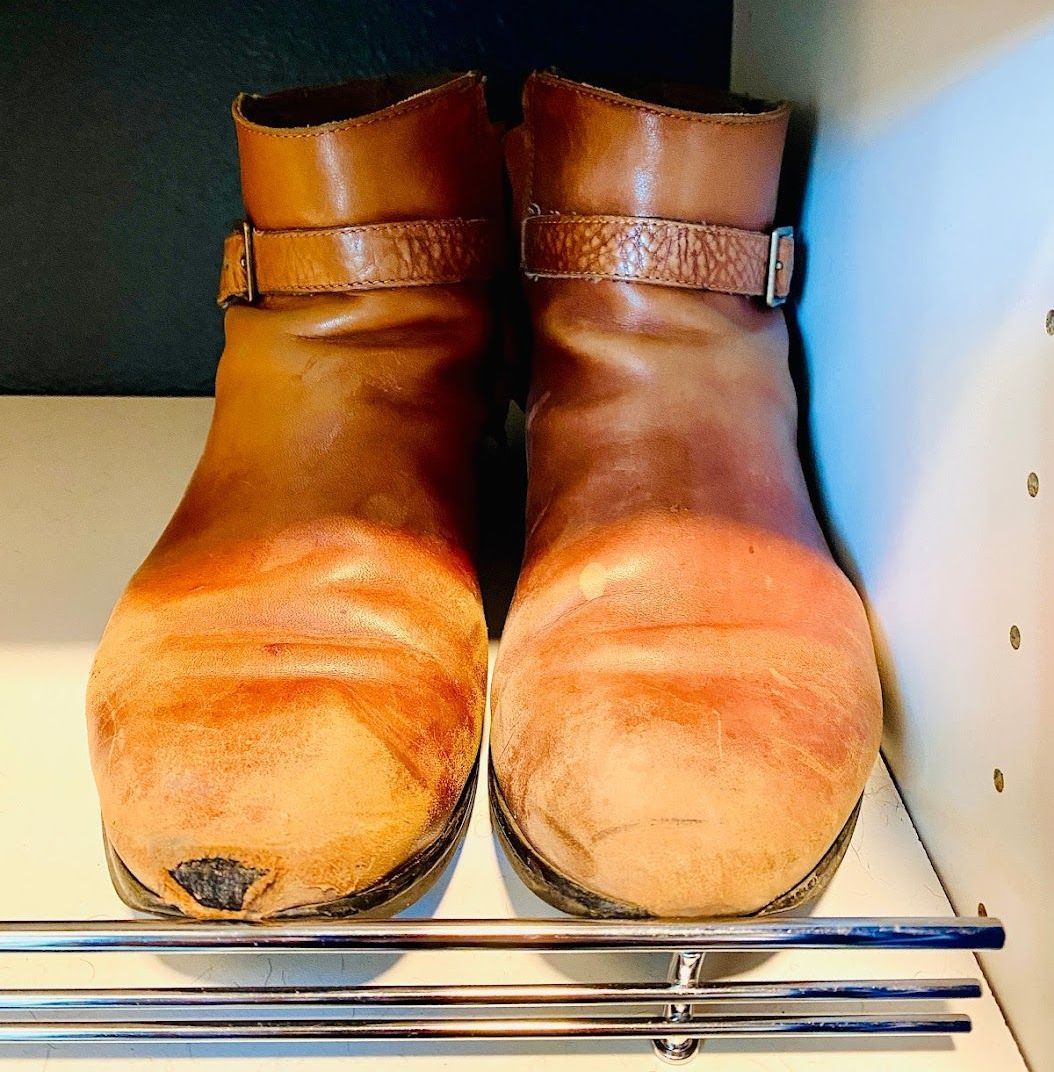 A pair of brown boots are sitting on a shelf