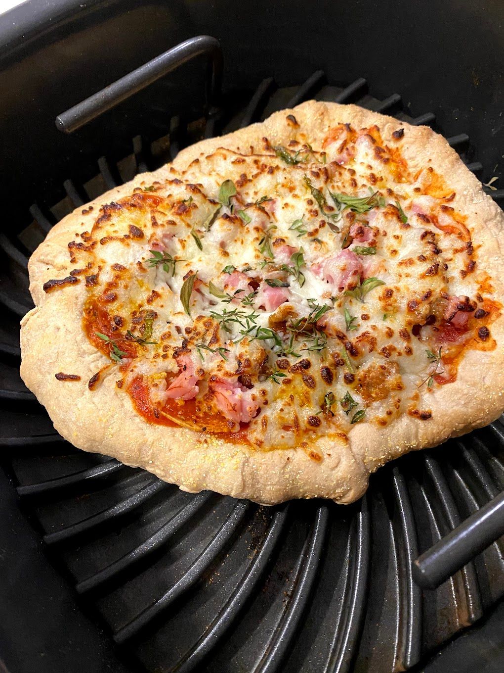 A pizza is sitting on top of a pan on a grill.