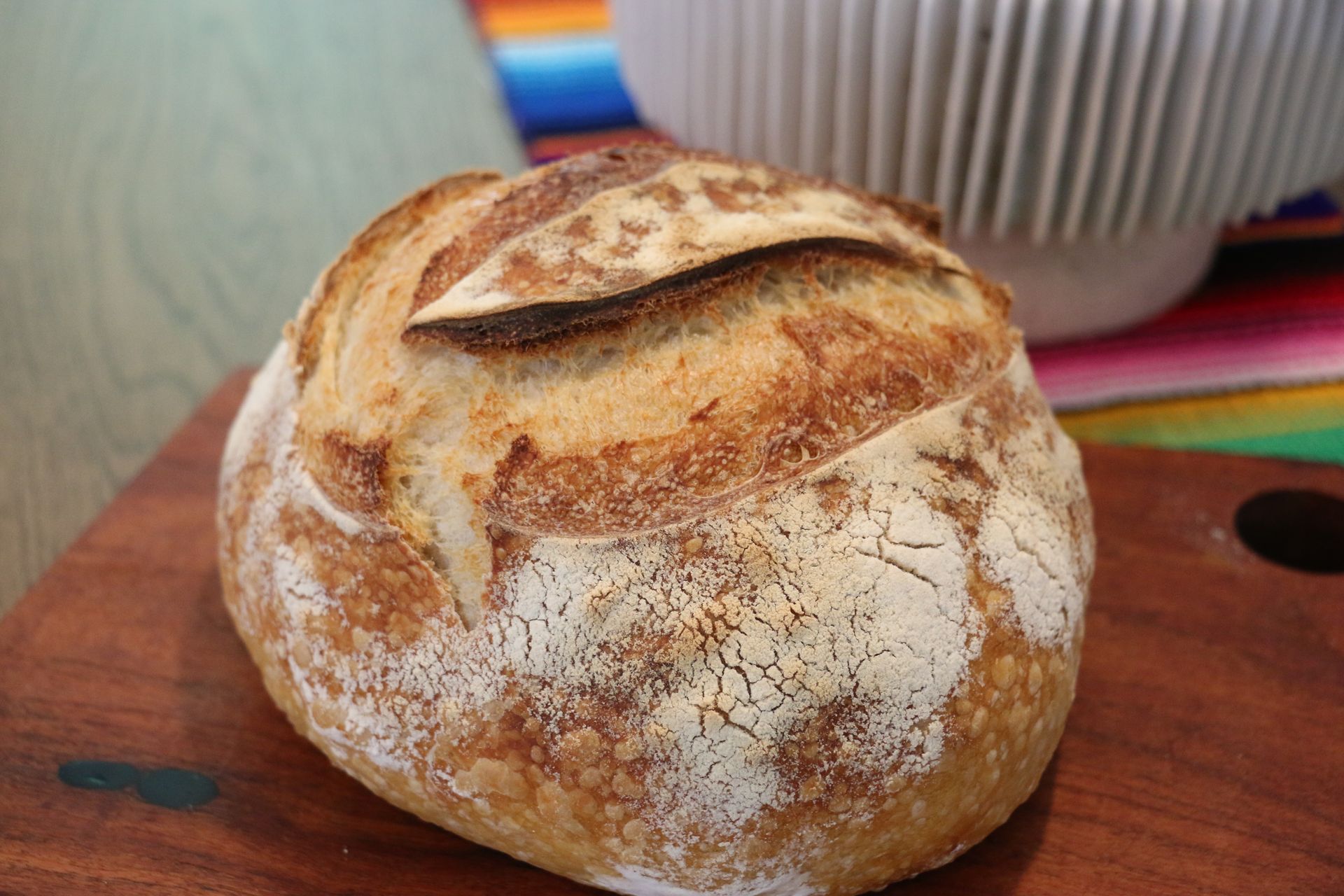 A loaf of bread is sitting on a wooden cutting board.
