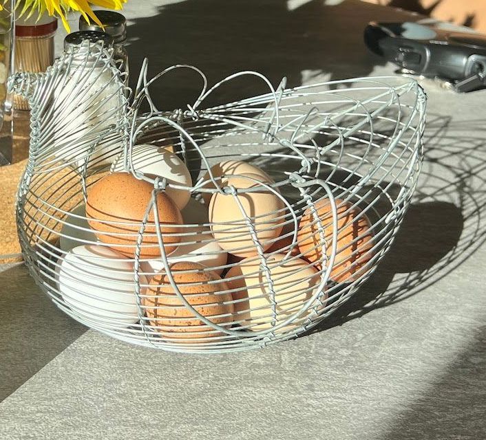 A wire basket filled with eggs on a table