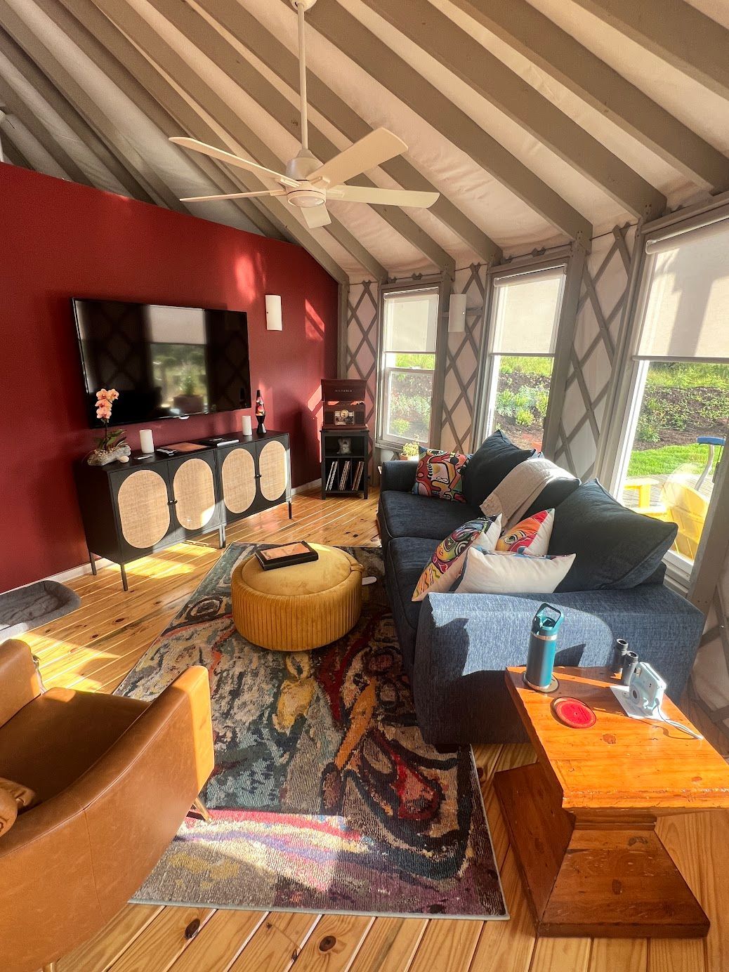 A living room with a couch , ottoman , table and television.