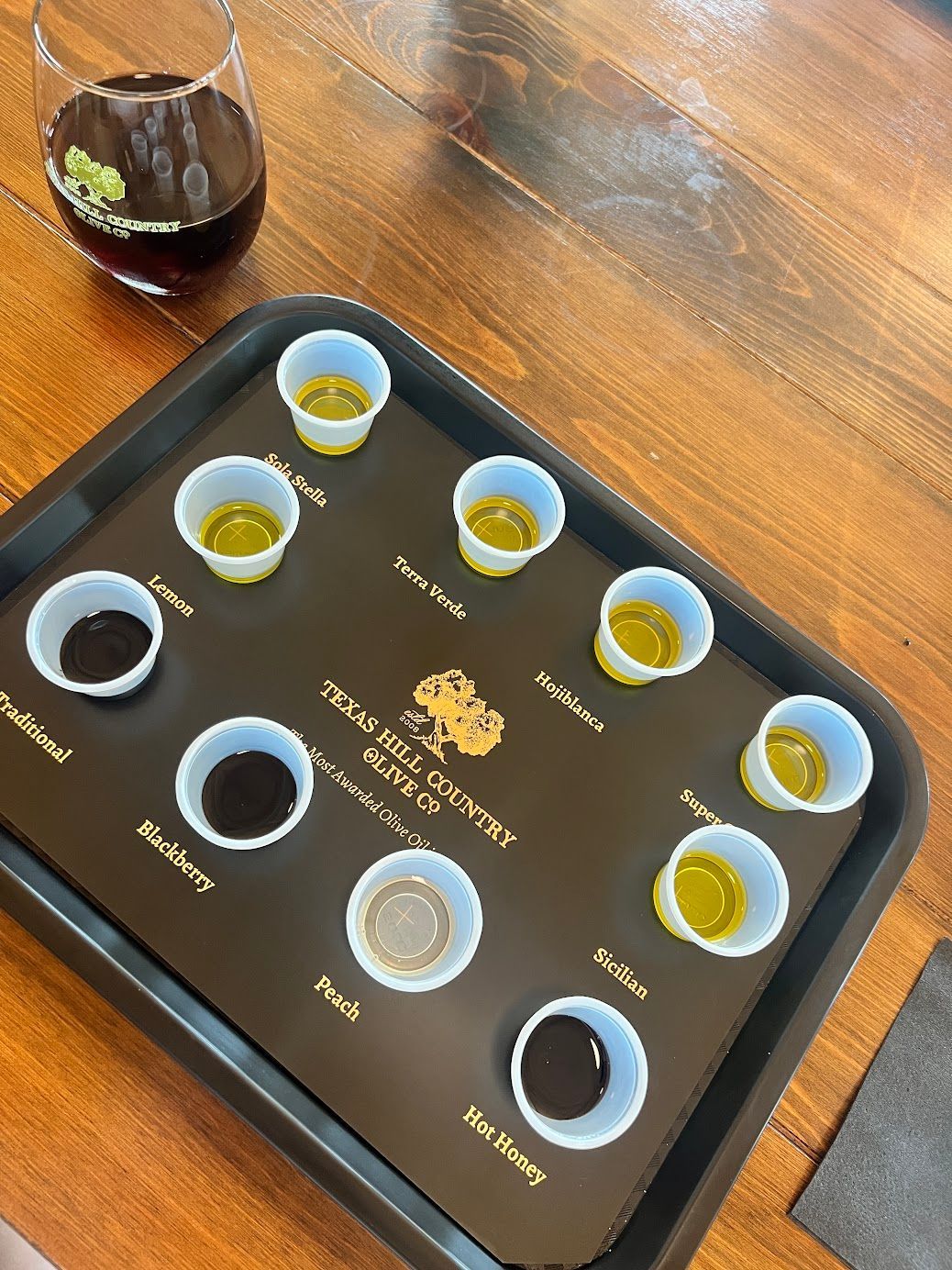 A tray with cups of different sauces on a wooden table.