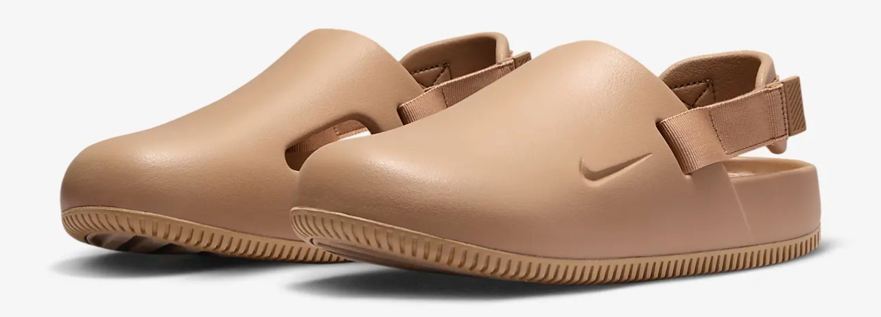 A pair of tan clogs with a strap on a white background.