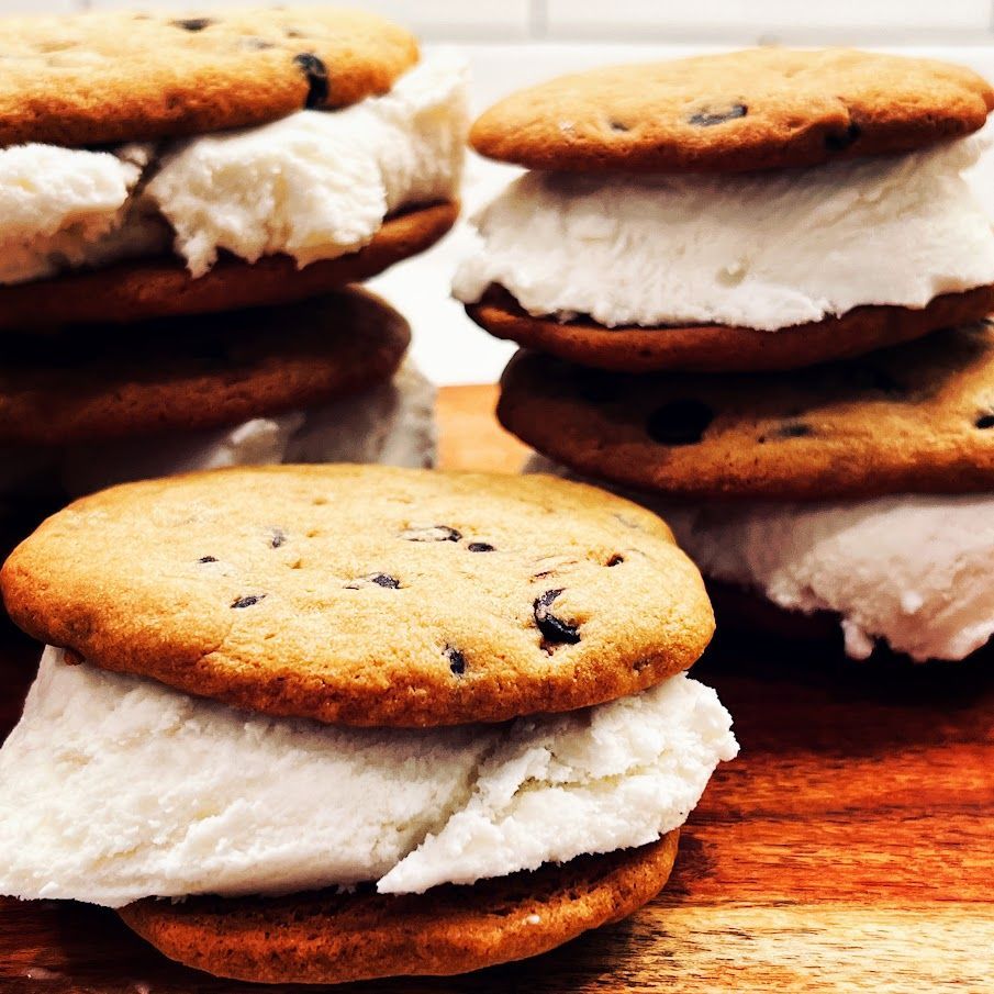 Ice cream sandwiches are stacked on top of each other on a wooden table