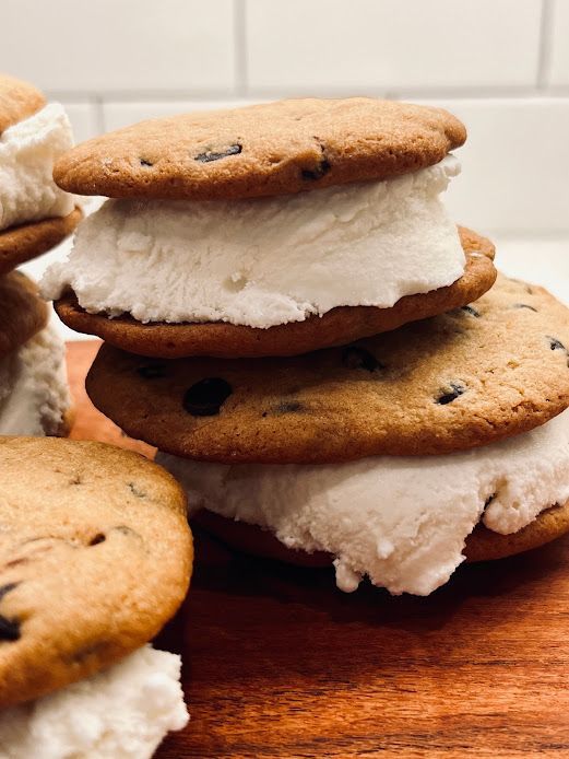 A stack of chocolate chip cookies with whipped cream on top