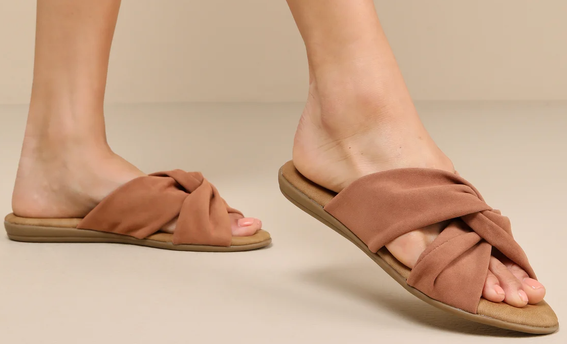 A woman is wearing a pair of brown sandals.