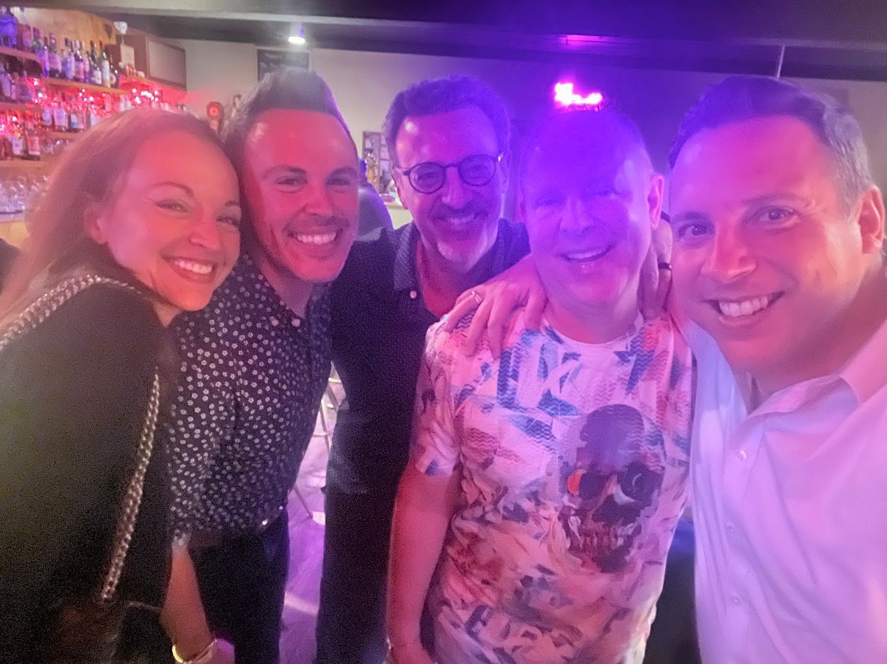 A group of people are posing for a picture in a bar.