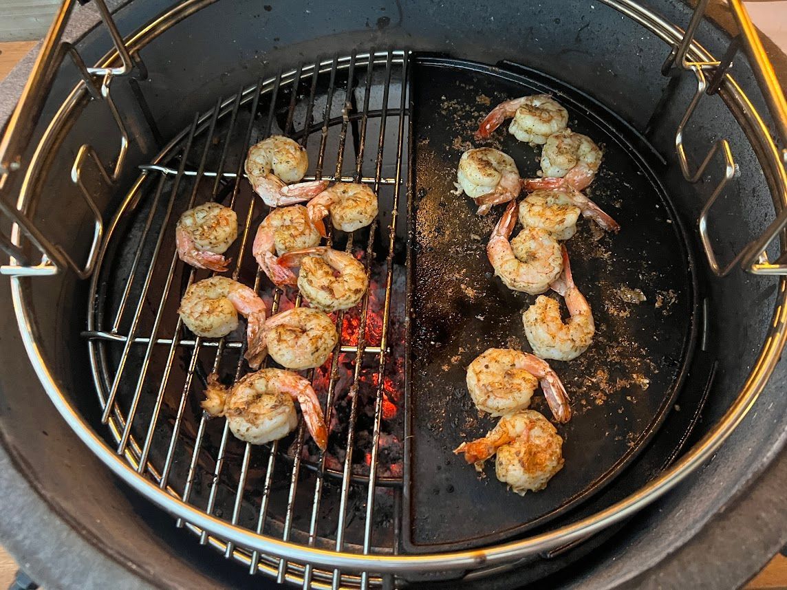 Shrimp are being cooked on a grill in a pan