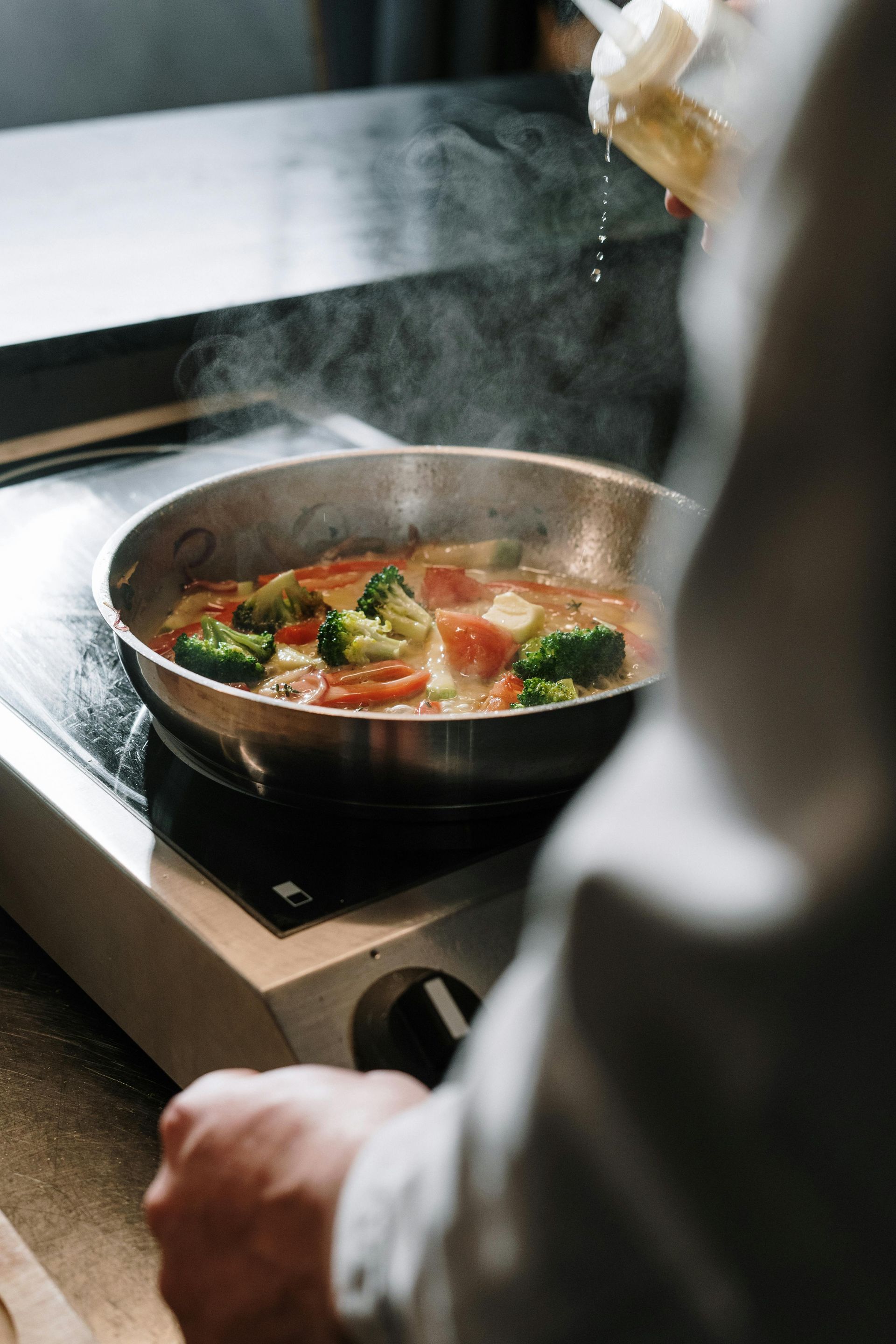 pan on a stove sautéing veggies