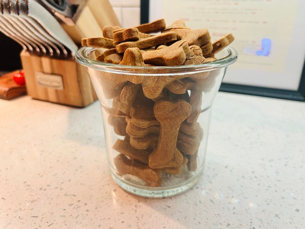 A glass filled with dog treats in the shape of bones