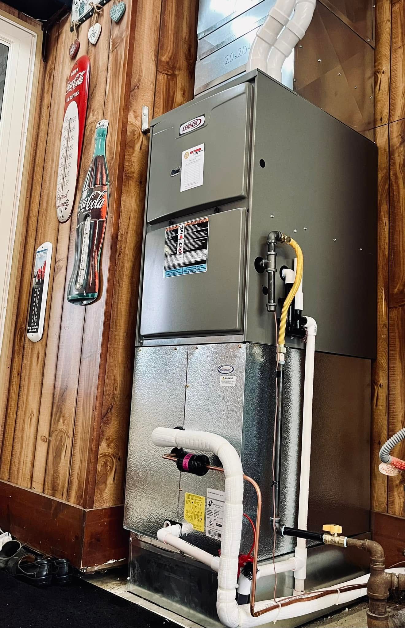 Gray HVAC furnace in a wood-paneled basement with exposed pipes and ductwork.