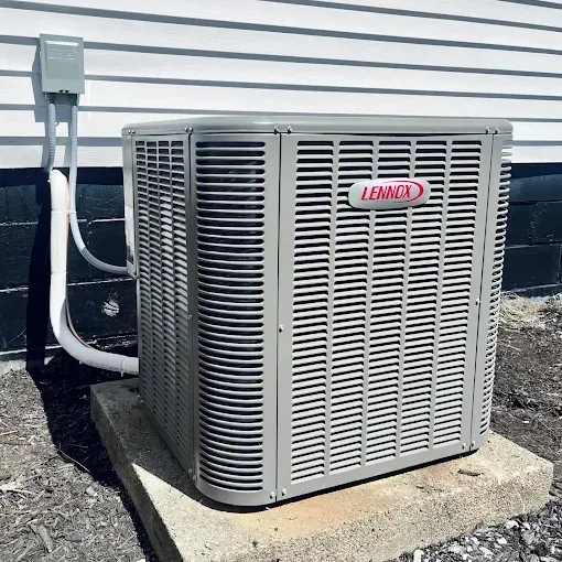 Outdoor Lennox air conditioner unit on a concrete pad beside a house wall