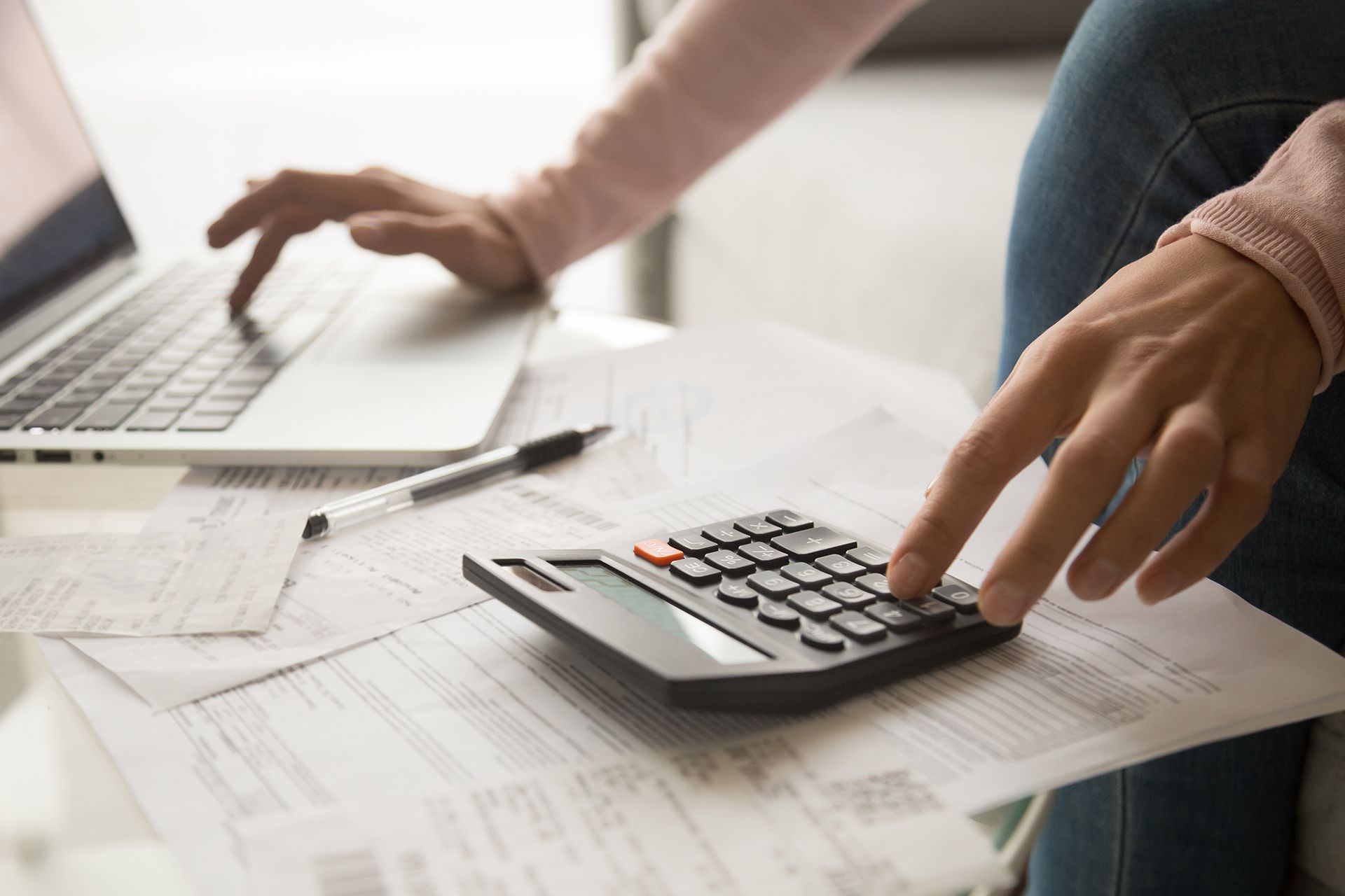 A person is using a laptop and a calculator at the same time.