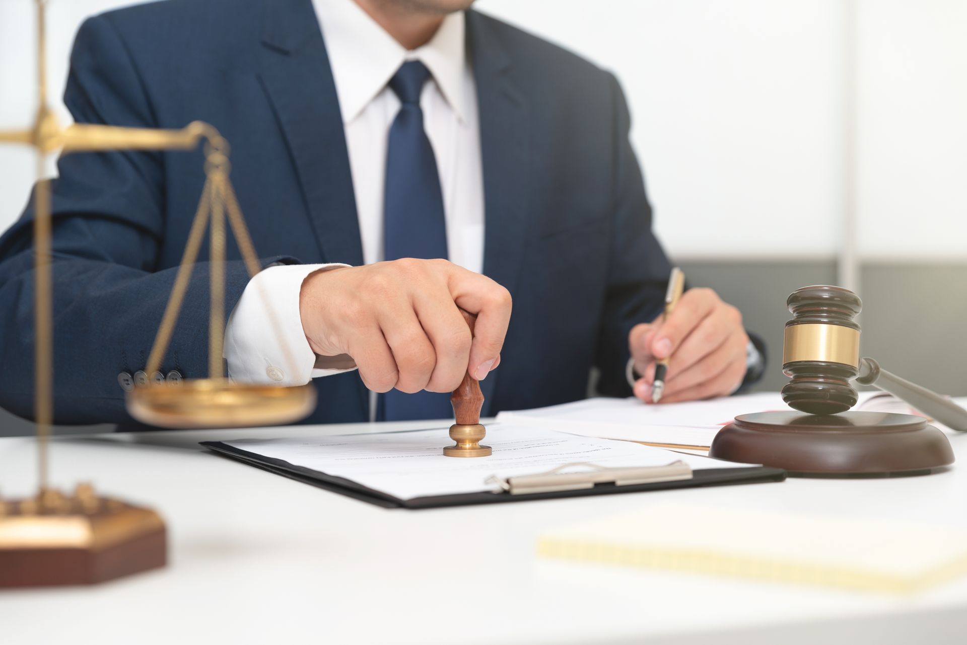 A man in a suit and tie is stamping a document on a clipboard.