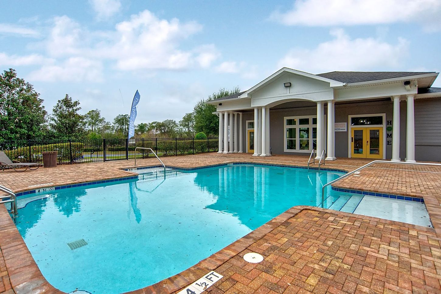 There is a large swimming pool in front of a building.
