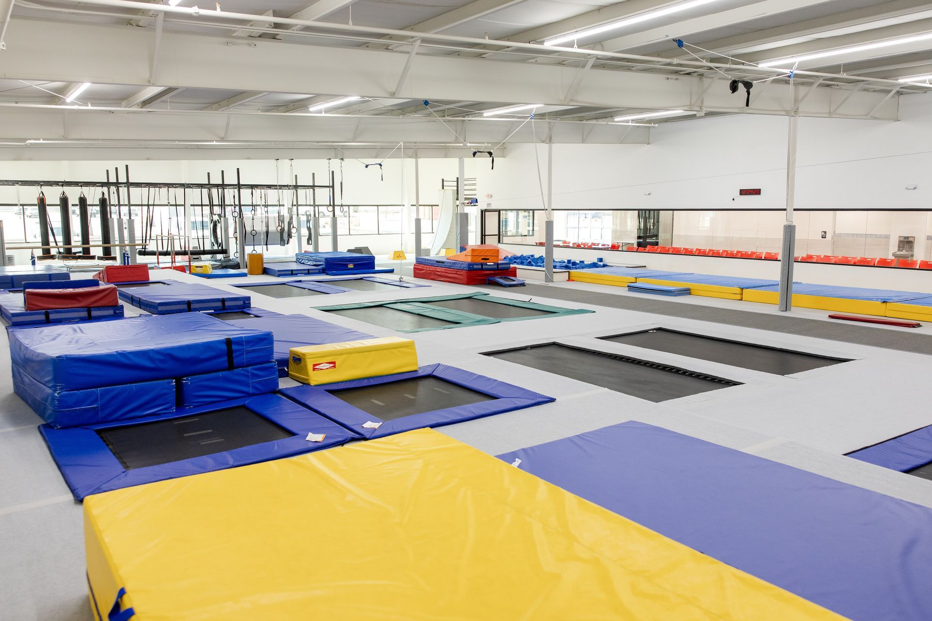 Gymnastics training facility with trampolines, blue mats, and yellow foam pads