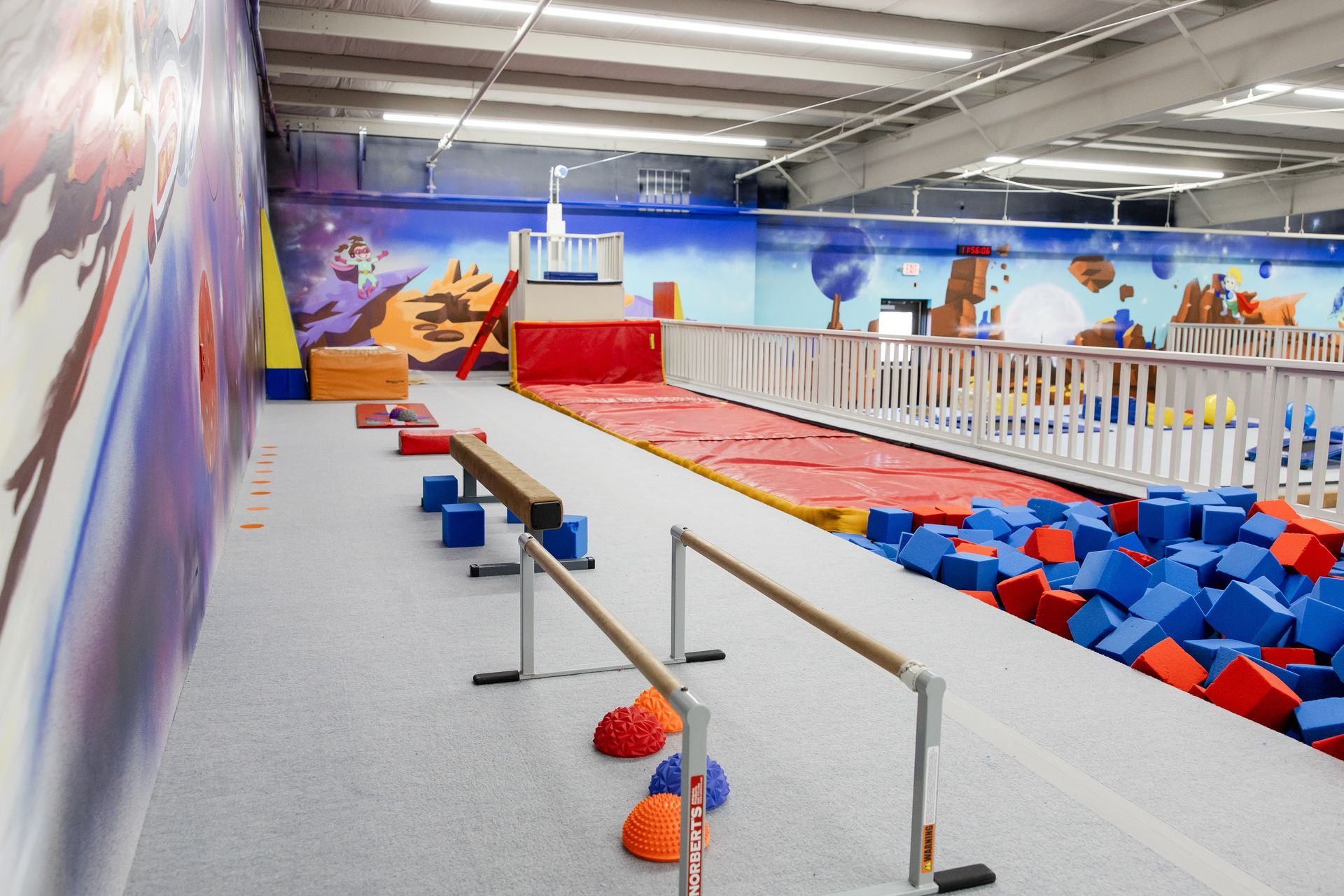 Indoor obstacle course with foam pit, zipline, and colorful play equipment