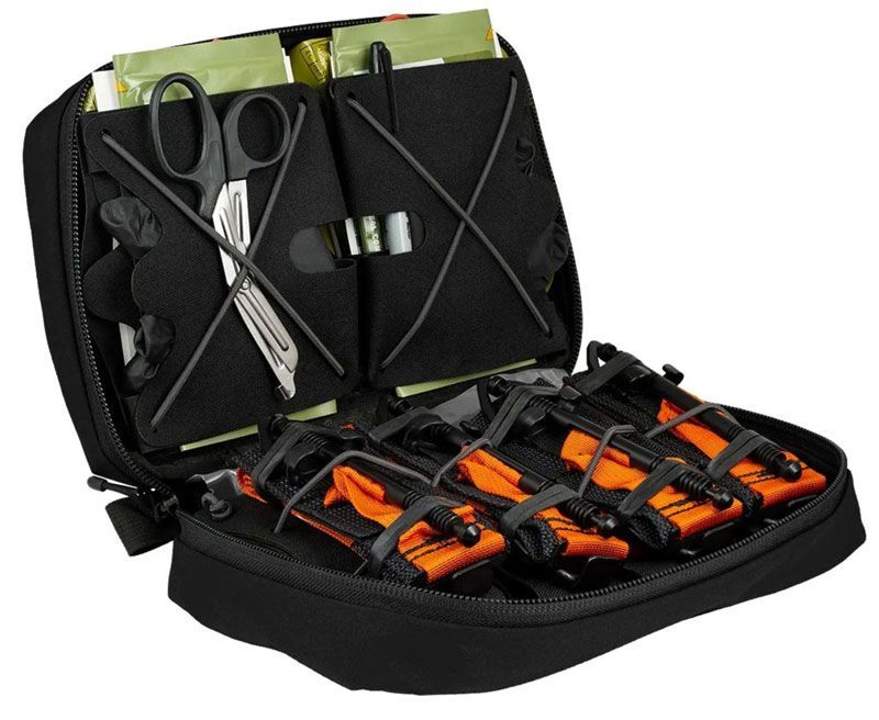 Open black first aid kit containing bandages, scissors, and tourniquets.