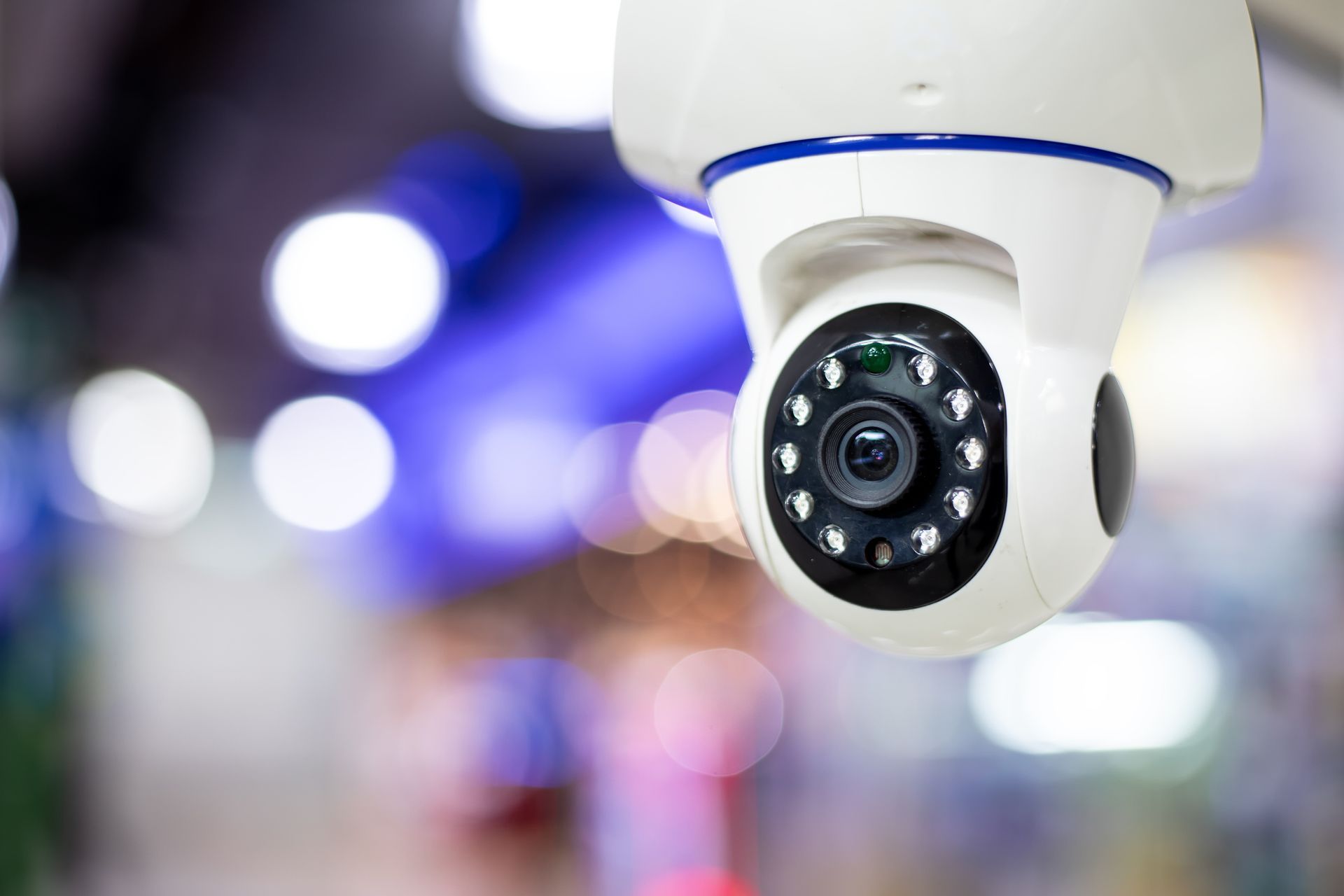 Close-up of CCTV security camera with infrared LEDs monitoring indoor space.