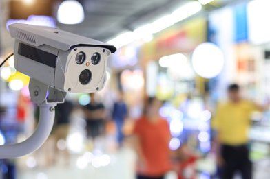 Security camera in a retail store, with shoppers blurred in the background.