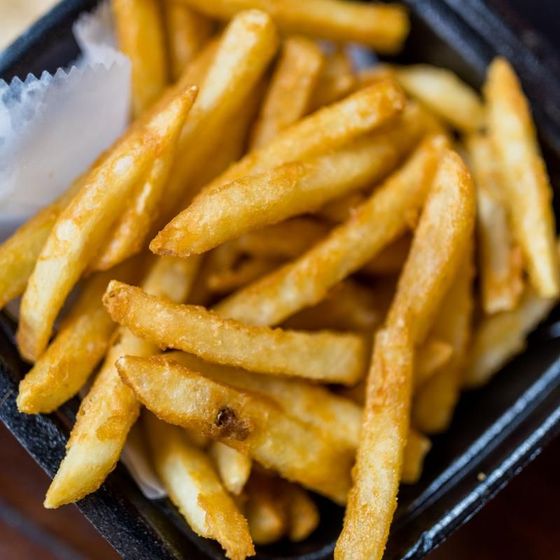 A close up of french fries in a black container
