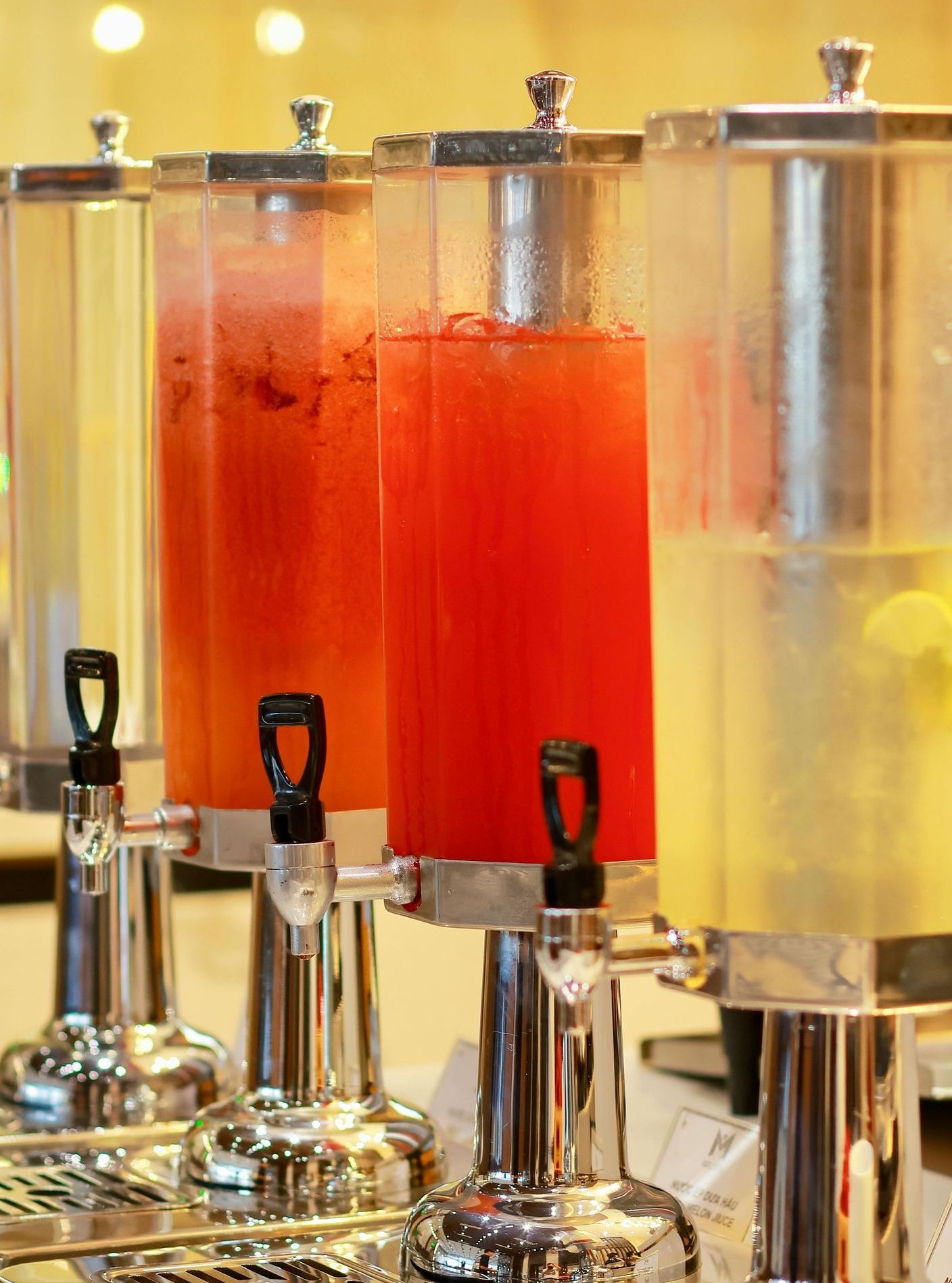 A row of beverage dispensers filled with different types of drinks.