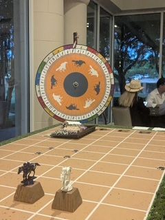 A spinning wheel with horses on it is sitting on top of a table.