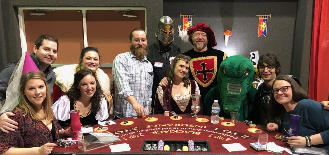 A group of people are posing for a picture in front of a table.
