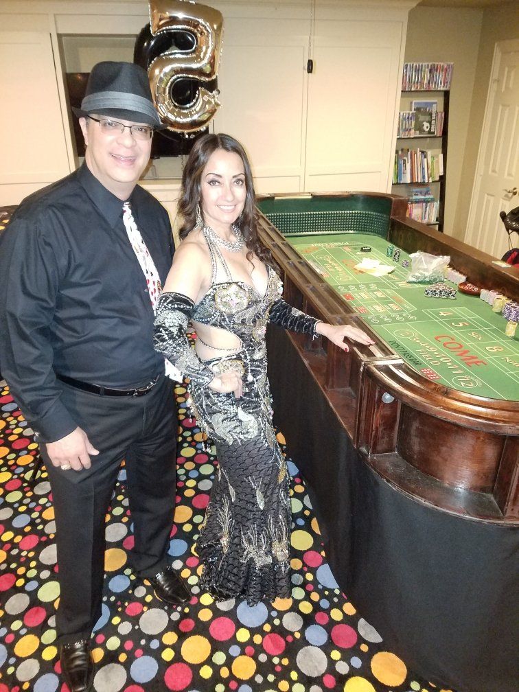 A man and a woman are standing in front of a casino table.