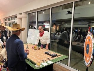 A man in a cowboy hat is playing a game at a table.