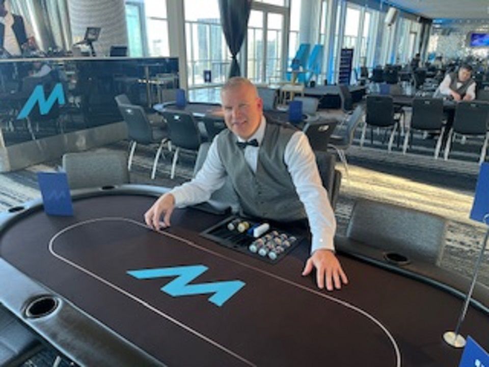 A man is sitting at a poker table in a casino.