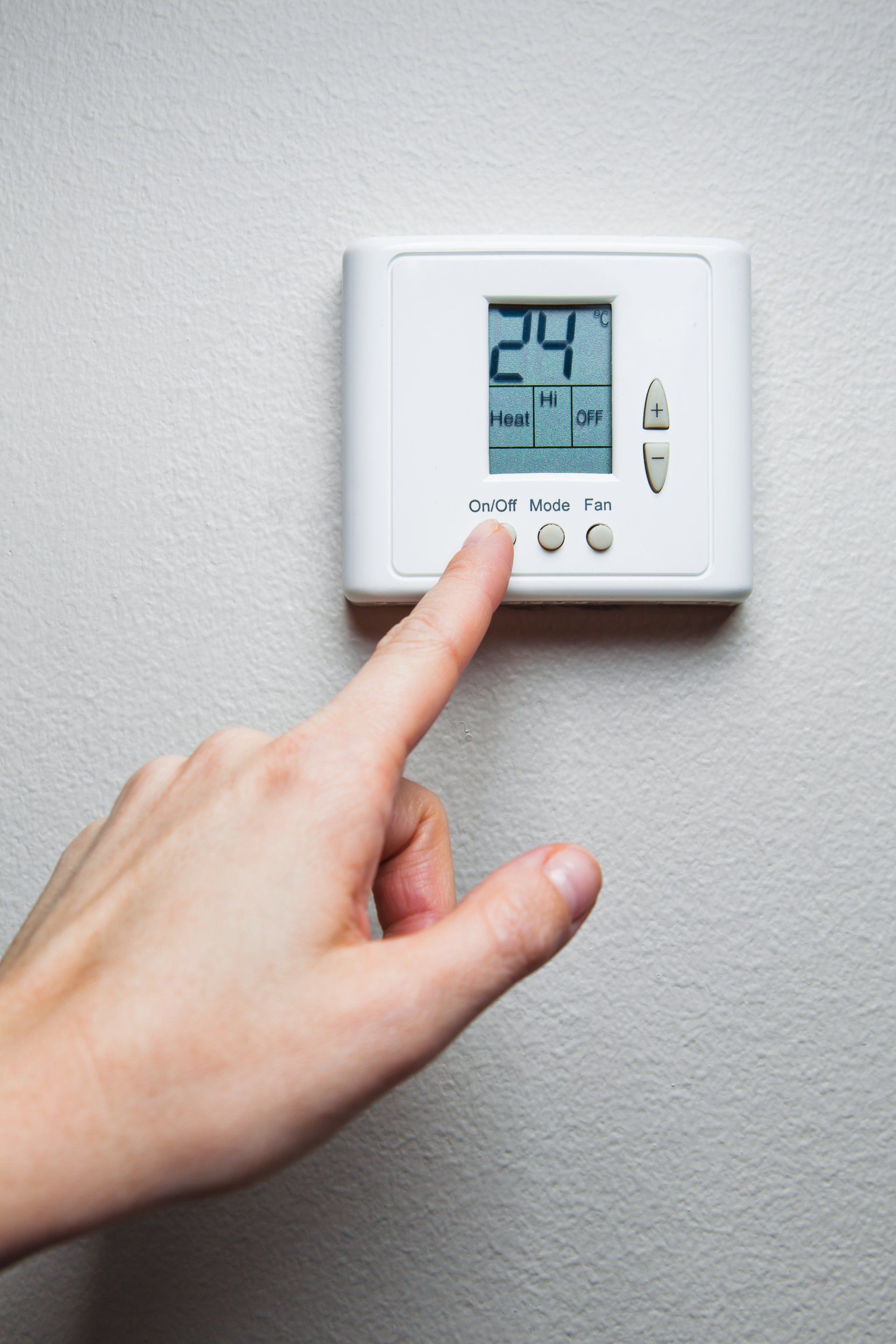 hand turning on digital climate control