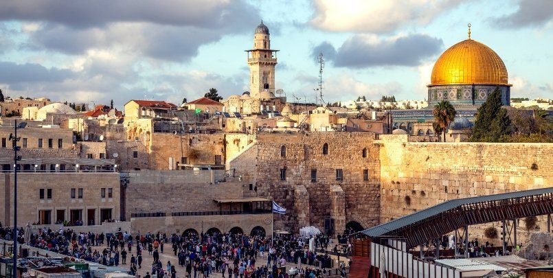 View of Jerusalem’s Western Wall and Dome of the Rock at sunset, with crowds below
