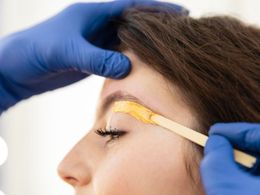 Woman having eyebrow waxed