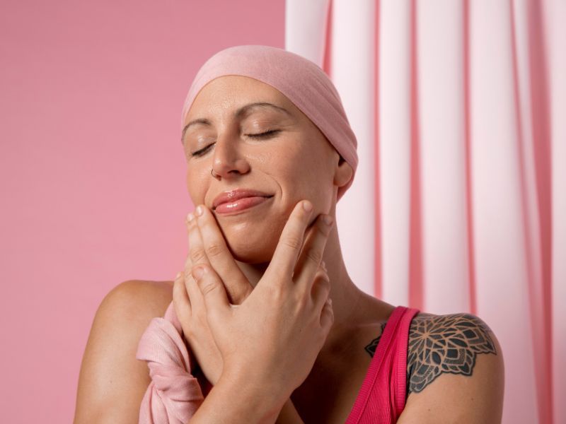 Woman with a tattoo holding her face