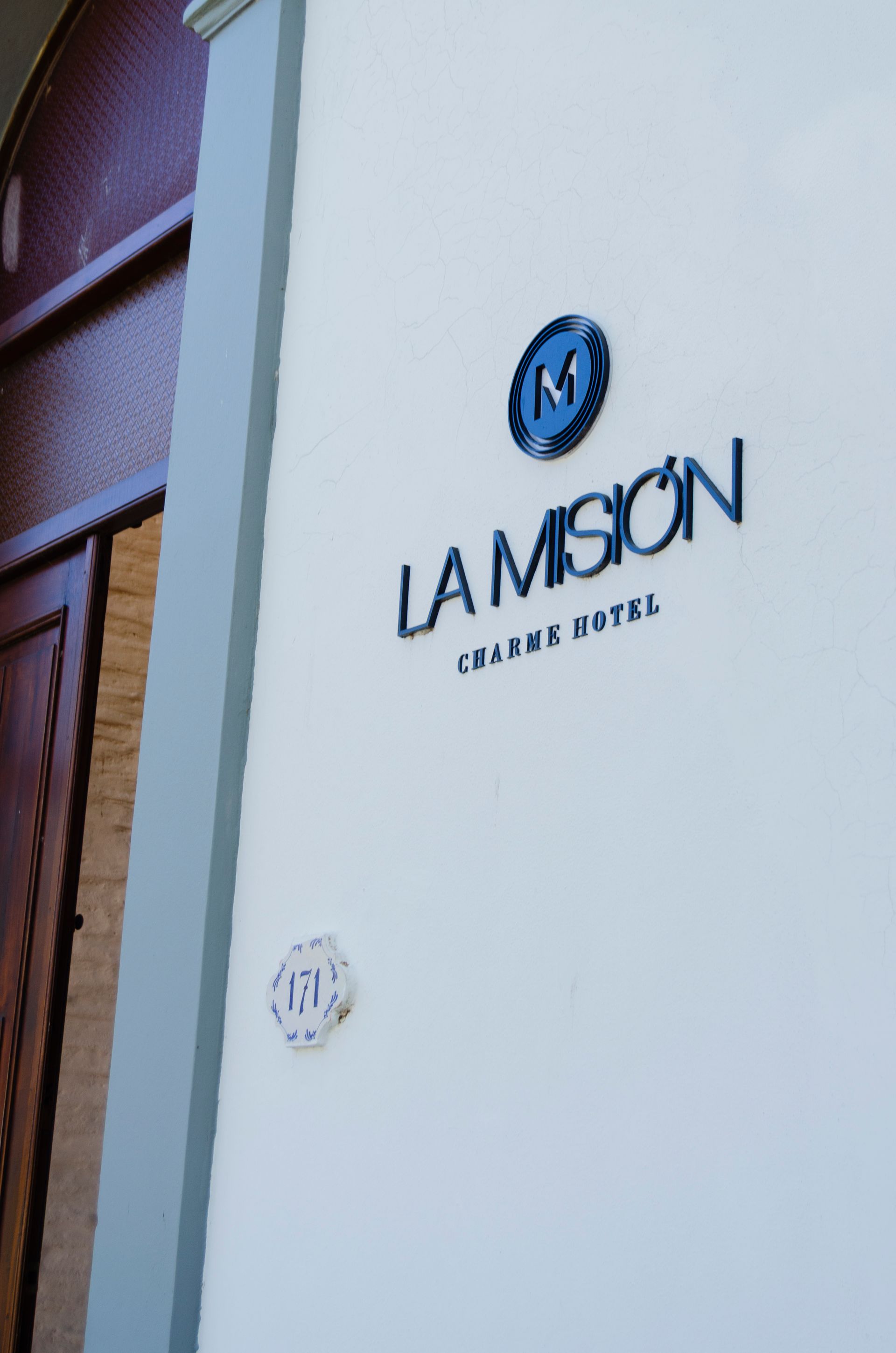 Una pared blanca muestra un logotipo circular azul con la letra 