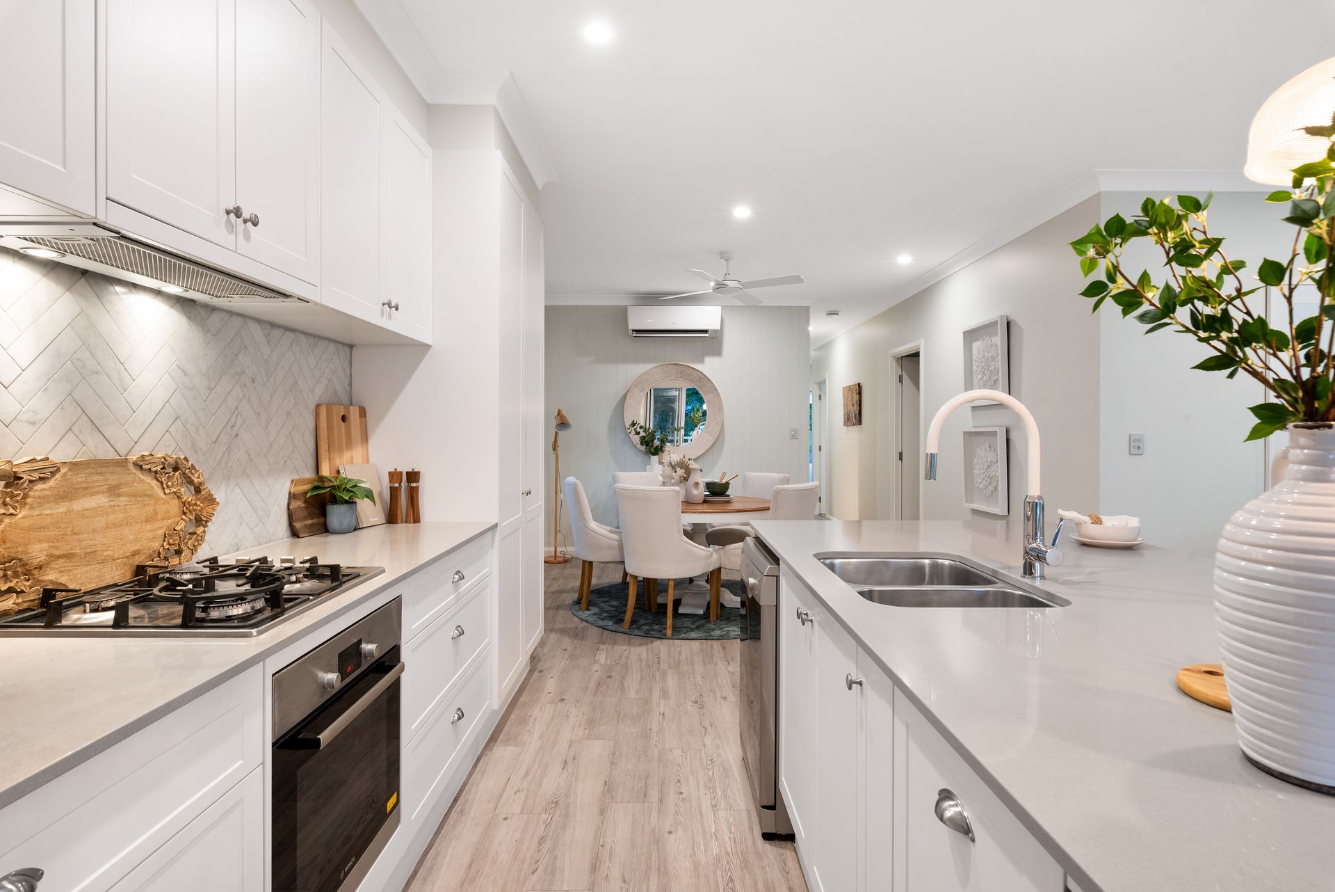 Clean and modern white ceramic tabletops with a sleek integrated sink in a spacious kitchen.