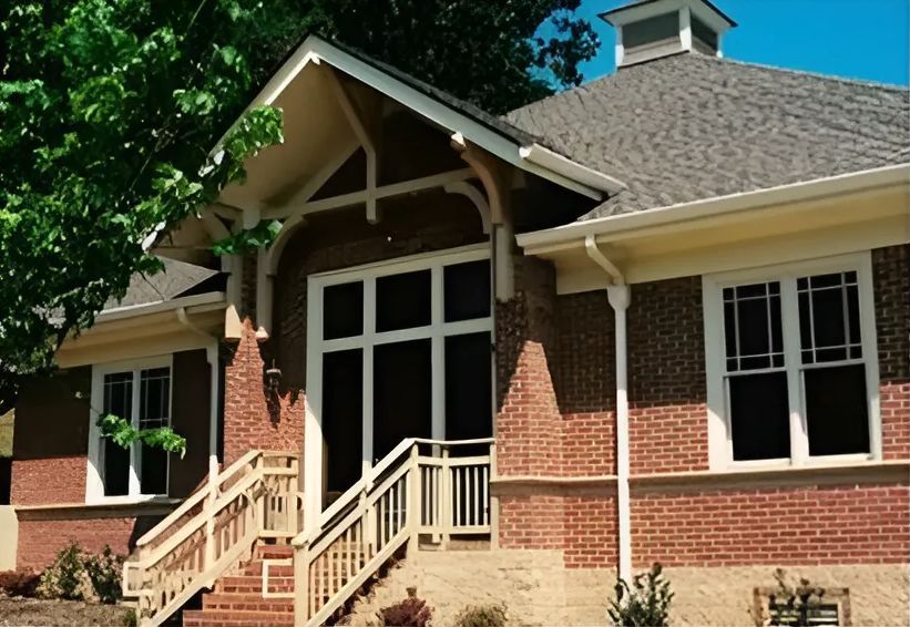A brick house with stairs leading up to the front door.