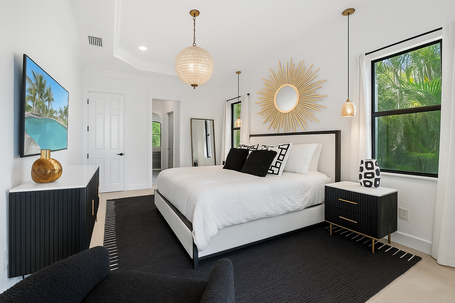 Bright modern bedroom with white bedding, black rug, gold accents, and large windows at CRAFTED 1111 fashion