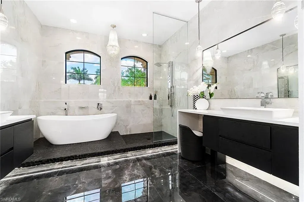 Modern black-and-white bathroom with a freestanding tub, double vanity, and large mirrors at CRAFTED 1111 fashion