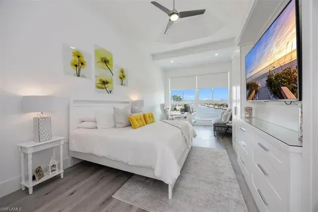 Bright white bedroom with yellow accents, a large bed, and a view into a balcony seating area at CRAFTED 1111 fashion